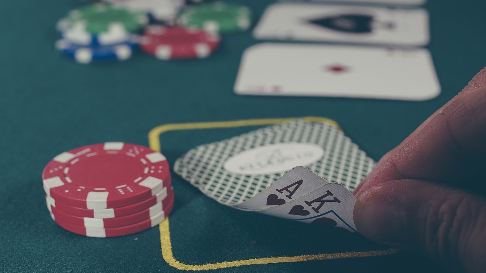 Chip poker dan kartu tergeletak di atas meja hijau